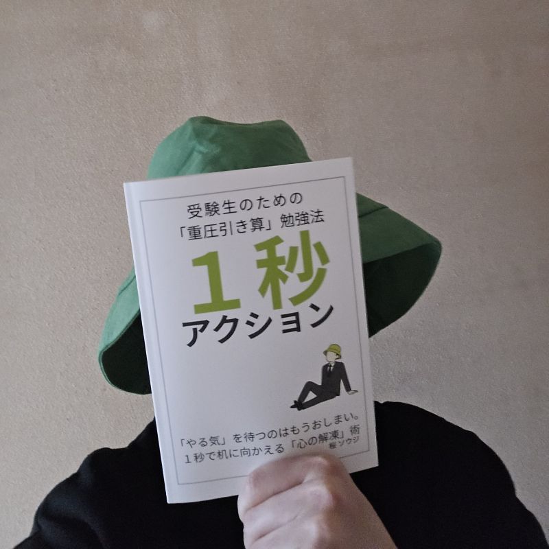 自著『1秒アクション』を手にする著者・桜ソウジ。実在の証明として初版の物理本を掲載しています。