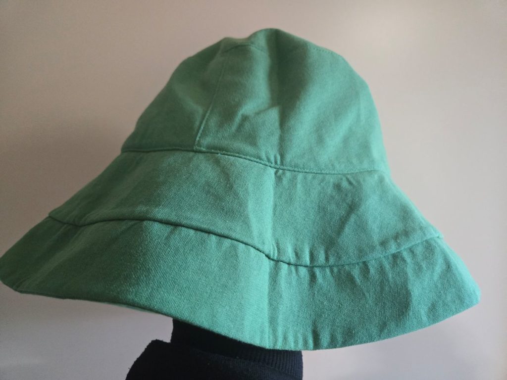 パソブロの原点となった緑色のバケットハットの実写。つばが広く、一見すると機能的な帽子。